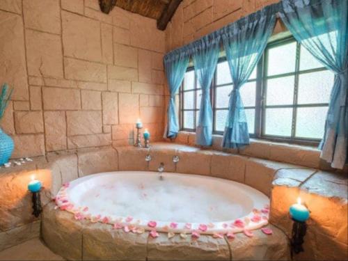 PelindabaMotozi Lodge的窗户客房内的大浴缸