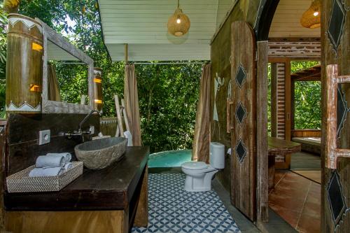 帕洋安Sacred Canyon Ubud by Pramana Villas的带浴缸、盥洗盆和卫生间的浴室