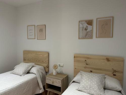 桑亨霍APARTAMENTOS MAR DE AREAS的一间带两张床和木制梳妆台的卧室