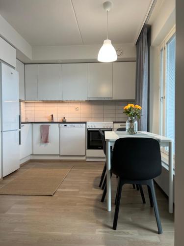 HyryläTyylikäs 35m2 yksiö Hyrylän keskustassa的厨房配有白色橱柜和桌椅