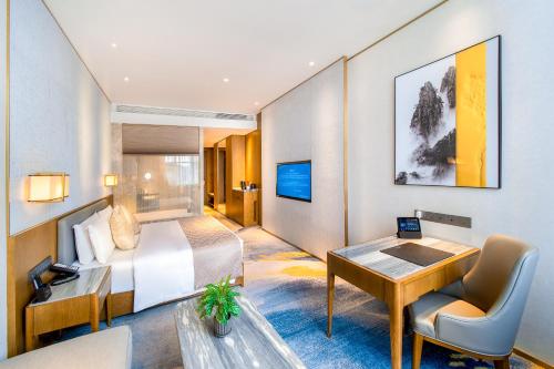 Shiyan十堰天海温德姆酒店的配有一张床和一张书桌的酒店客房
