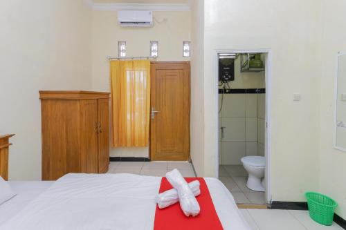 岩望RedDoorz Syariah near Alun Alun Pasuruan的一间卧室设有一张床、淋浴和卫生间