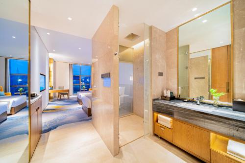 Shiyan十堰天海温德姆酒店的一间带大镜子的浴室和一间卧室