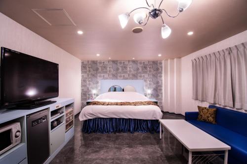 天理市Koriyama Flower Style的配有一张床和一台平面电视的酒店客房
