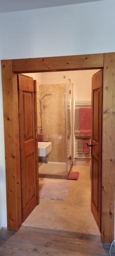 韦扎诺Ex Pretura Austriaca的通向带淋浴和盥洗盆的浴室的开放式门