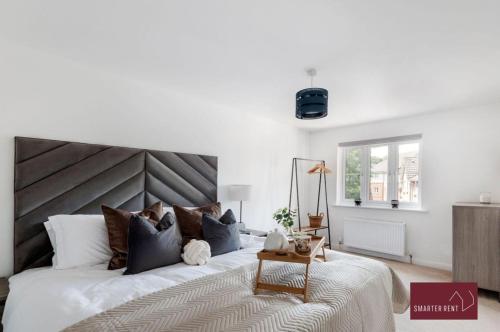 吉尔福德Guildford - 3 Bedroom Home - Driveway & Garden的一间卧室配有一张大床和木制床头板