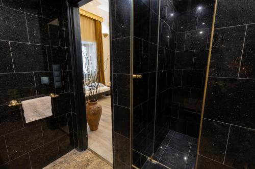 布达佩斯朋友旅馆公寓的浴室设有黑色瓷砖淋浴。