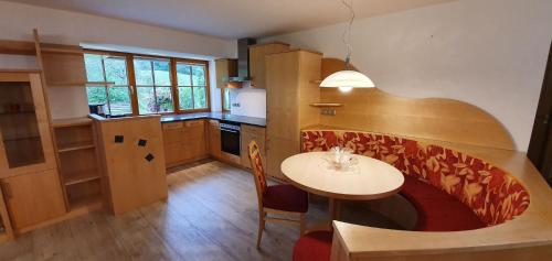 魏斯布里阿赫Berghof Reiter的厨房配有桌子和小桌子及椅子
