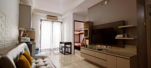 雅加达Spacious & Cozy 27FL - 2BR Apartment West Jakarta的带沙发和平面电视的客厅