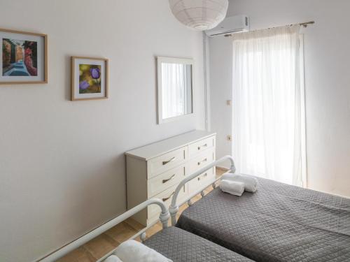 卡沃斯Andronikos Guest House的一间卧室配有一张床、一个梳妆台和一扇窗户。
