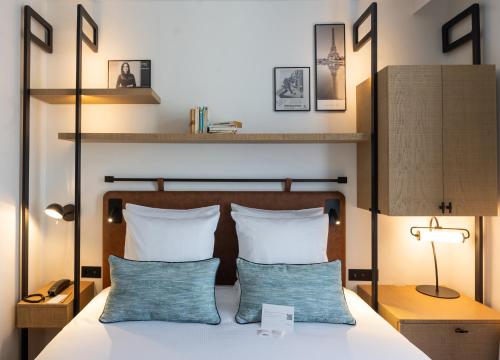 巴黎Esteem Tour Eiffel的一间卧室配有一张带两个蓝色枕头的床