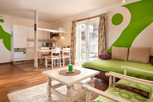 弗拉绍加尼塔伦霍夫公寓式酒店的客厅配有绿色沙发和桌子