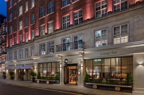 伦敦The May Fair, A Radisson Collection Hotel, Mayfair London的建筑的外墙,有一座大砖砌的建筑