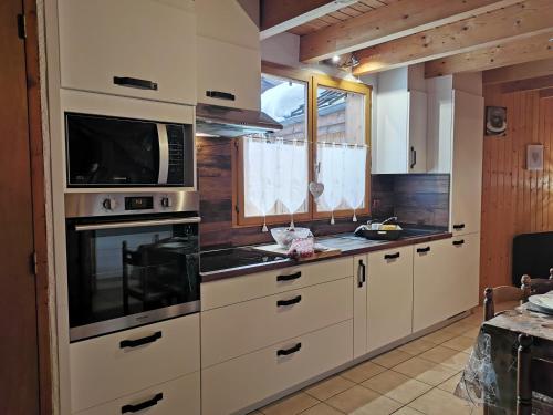 雷加霍斯达哈施Demi-Chalet l'Ancolie -- Prox pistes的厨房配有白色橱柜和微波炉