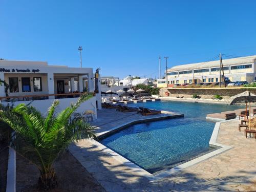 纳克索乔拉Naxos Village hotel的一座与度假村相连的建筑旁边的游泳池