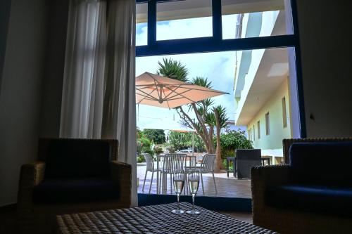 兰佩杜萨Hotel Baia Turchese的庭院配有遮阳伞和桌椅。
