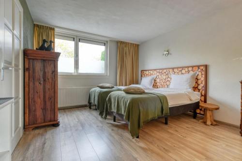 豪滕Borneman Buitenhof - Privé Appartement的一间卧室设有两张床和窗户。