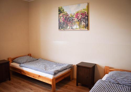 大波兰地区奥斯特鲁夫Hostel Sadowianka的一间设有两张床的客房,墙上挂着一张照片