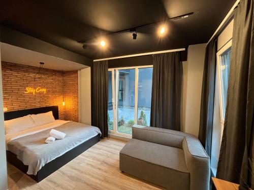 马夫罗沃Mickitos Apartments - Mavrovo的卧室配有床、椅子和窗户。