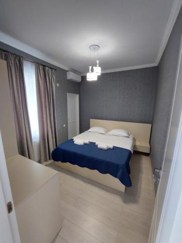 西格纳吉Apartment in Sighnaghi的一间卧室配有一张带蓝色床单和白色枕头的床。