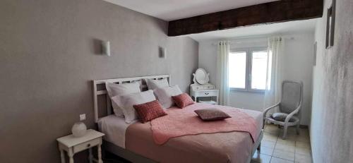 艾格-莫尔特La flemme en rose的卧室配有一张大床,配有粉色床单和枕头