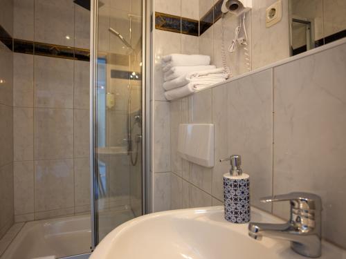 克里米乔Hotel Mauritius的一间带水槽和玻璃淋浴的浴室