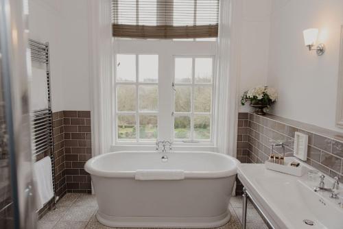 利兹兀兰酒店的带窗户的浴室内的白色浴缸