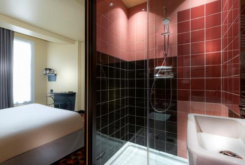 巴黎卡纳尔里贝德尔酒店的带淋浴和盥洗盆的浴室以及1张床。