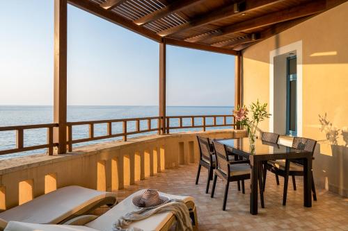 帕诺尔莫斯雷斯蒙Captain's House Hotel Suites & Apartments的一个带桌椅的海景阳台