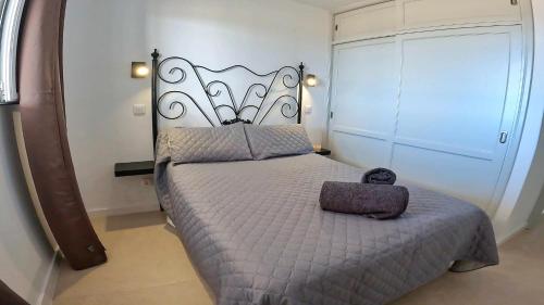 宏达海滩Apartamento Tierra, Primera línea Mar的一间卧室,配有一张带金属床头板的床