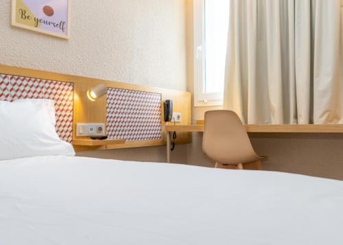 奥埃拉斯Flag Hotel Lisboa Oeiras的卧室配有床、椅子和窗户。