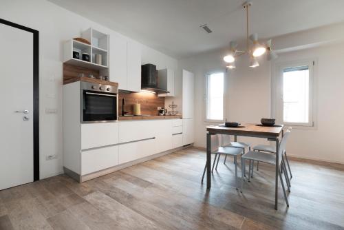 梅斯特Residence Cavalli的厨房配有白色橱柜和桌椅