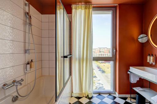 敦刻尔克Mercure Dunkerque Centre Gare的带淋浴和盥洗盆的浴室以及窗户。