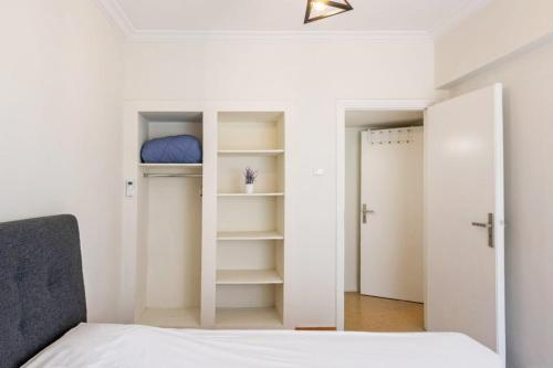 雅典Spacious 3 bedroom apt in Eksarchia的一间卧室配有一张床和一个带镜子的衣柜