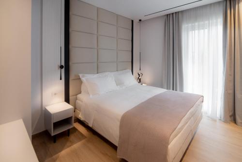 科孚镇Contessa Bianca Luxury Suites的卧室设有白色的床和大窗户