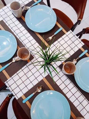 加影'Adn Homestay的一张桌子,上面有蓝色的盘子和勺子