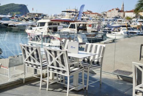 布德瓦Luxury Hotel Riva - Budva的船上的桌子和椅子