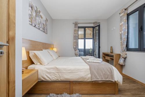 莫尼兹港Salsa Country House II by Madeira Sun Travel的一间卧室设有一张大床和一个窗户。