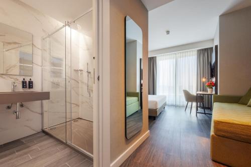 米兰IH Hotels Milano Centrale的酒店客房设有淋浴和一间卧室。