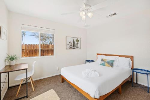 二十九棕榈村Cassia Tree的一间卧室配有一张床、一张书桌和一个窗户。