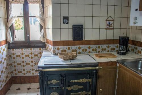 Murueta-Orozkocaserio vasco con piscina y barbacoa的厨房配有旧炉灶和水槽。