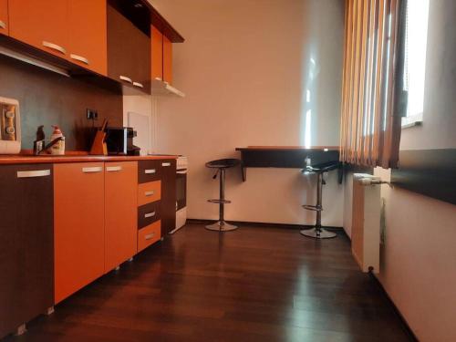 阿拉德Apartament cu parcare privata的铺有木地板的厨房配有橙色橱柜
