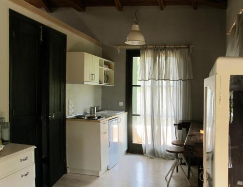 寇特Chorto Garden Home的厨房配有白色橱柜、水槽和冰箱。