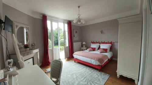 康布勒梅尔La Villa des Tilleuls的一间卧室配有一张带红色窗帘的床和壁炉