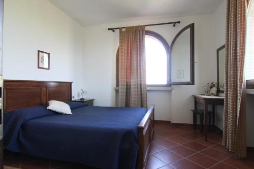 帕贾尼克Agriturismo La Steccaia Alta的一间卧室设有蓝色的床和窗户。