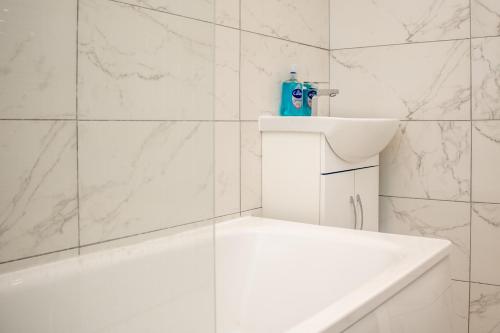 安特里Pleasant City Escape的白色的浴室设有白色浴缸和水槽。