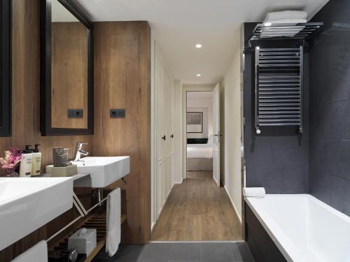 巴塞罗那H10卡萨诺瓦酒店的浴室配有2个盥洗盆和1个浴缸。