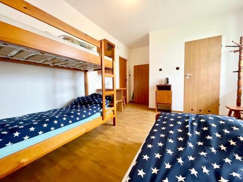 弗瓦迪斯瓦沃沃Promyk的一间卧室配有两张双层床和美式旗毯