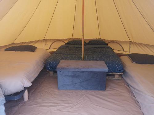 MollesSous les Toiles de PauTiLou的帐篷配有两张床和一张桌子