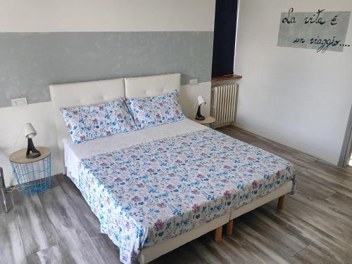 卡萨诺韦Sleep & Fly Malpensa的一间卧室配有一张带蓝色和白色棉被的床